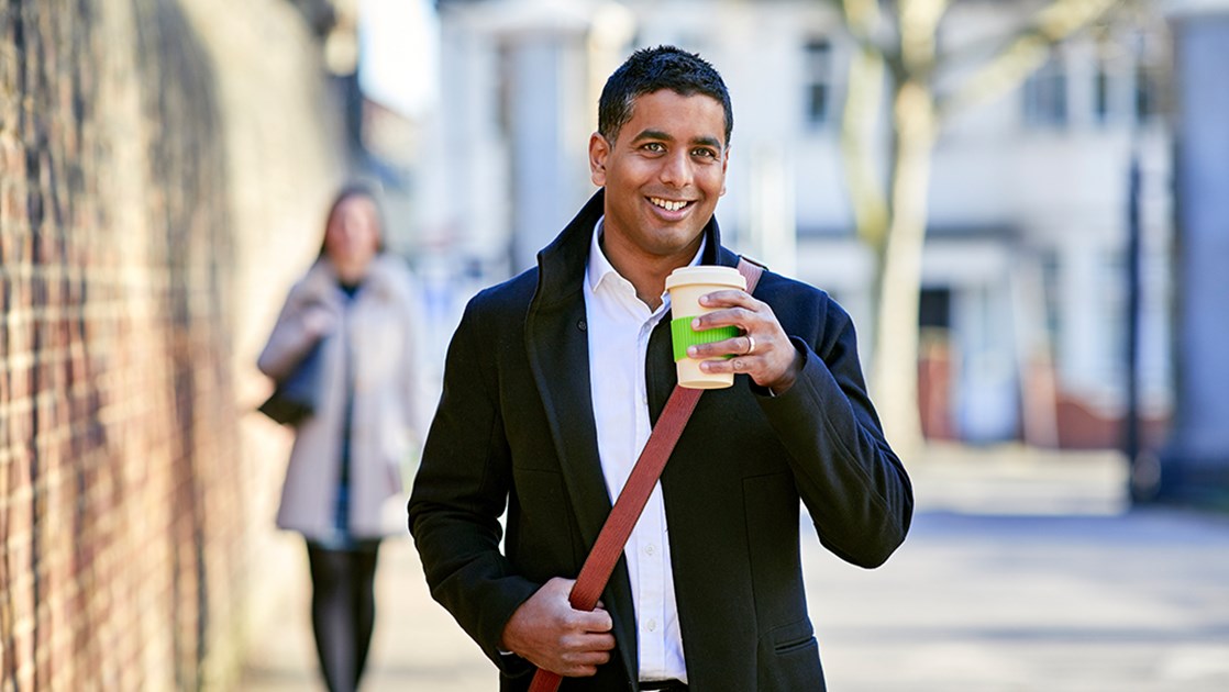 Mann Mit Kaffeebecher In Der Hand Laechelt