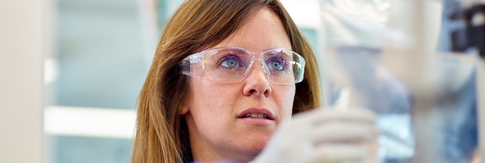 Frau im Labor mit Schutzbrille