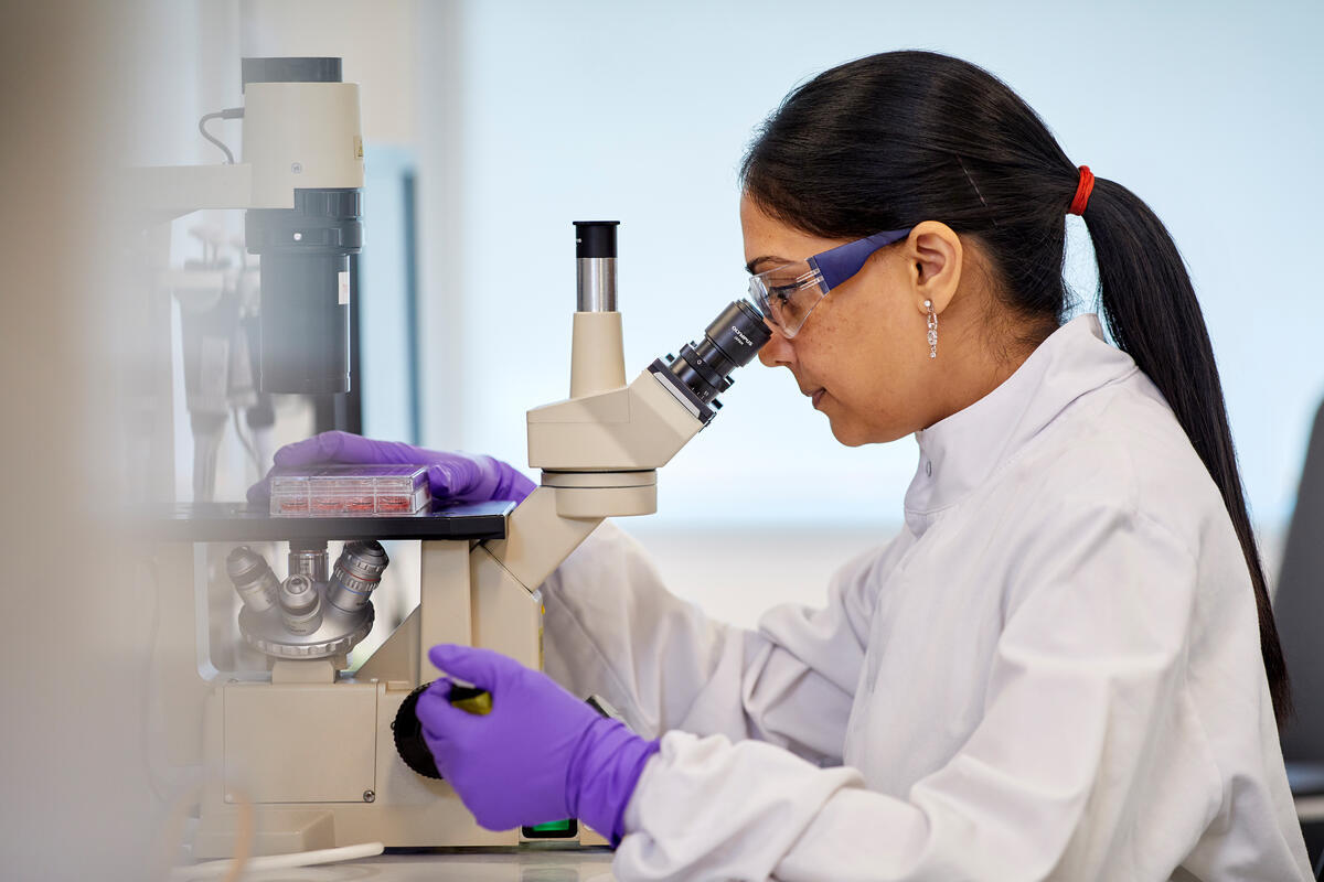 Wissenschaftlerin an einem Mikroskop