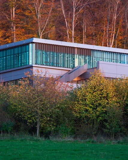 Gebäude vor herbstlichen Wald