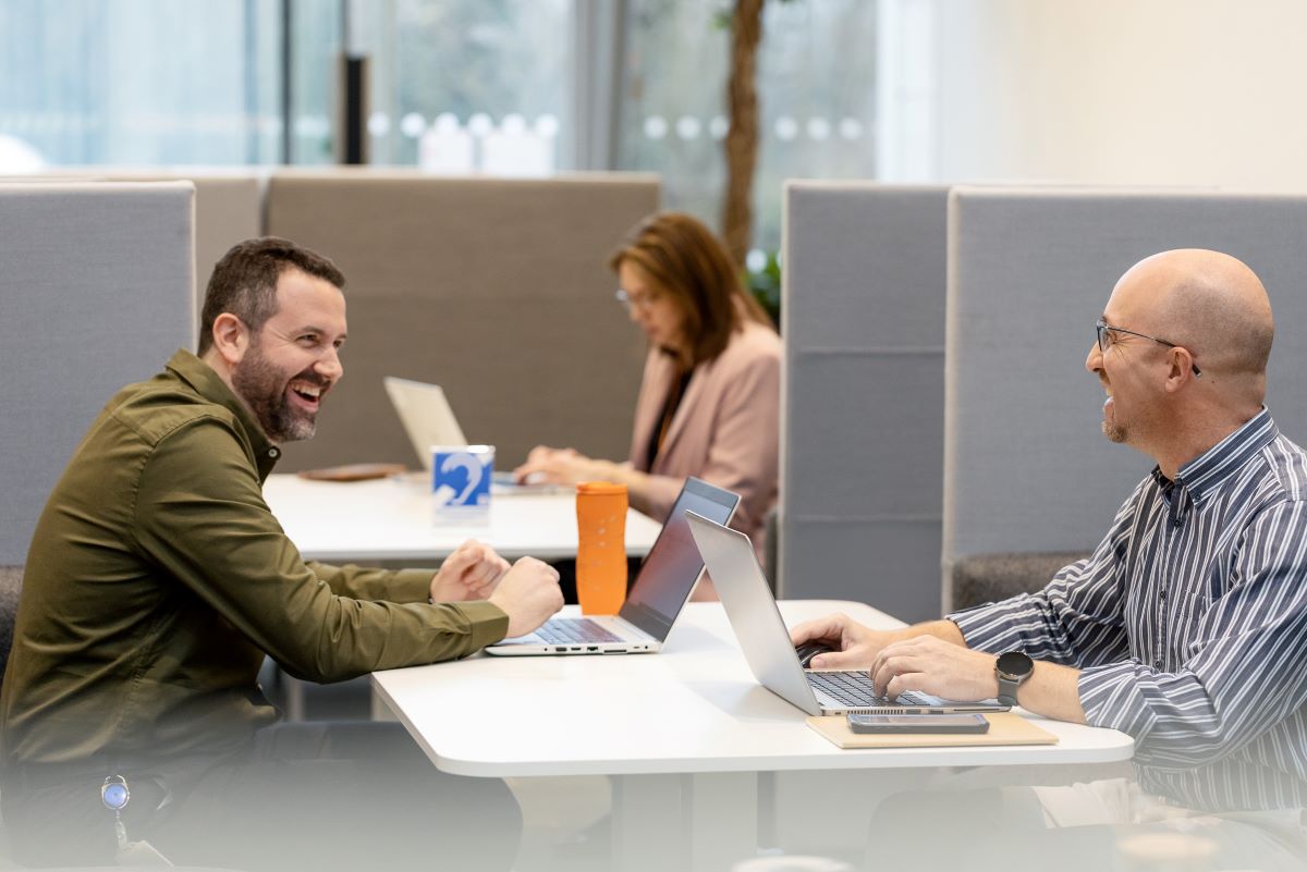 Männer arbeiten zusammen am Laptop