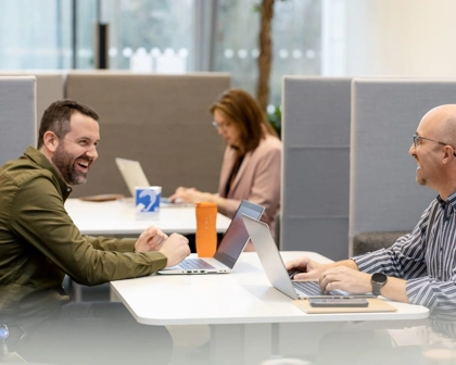 Männer arbeiten zusammen am Laptop