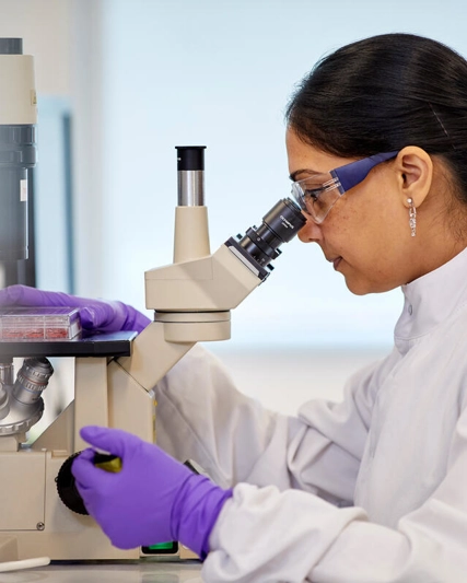 Wissenschaftlerin an einem Mikroskop