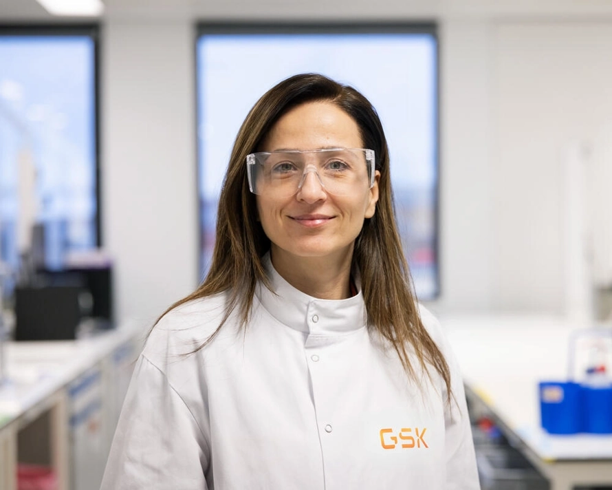 Lab scientist wearing safety glasses looking at camera